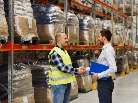 worker and businessmen with clipboard at warehouse