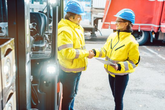 Worker and manager shaking hands at distribution center